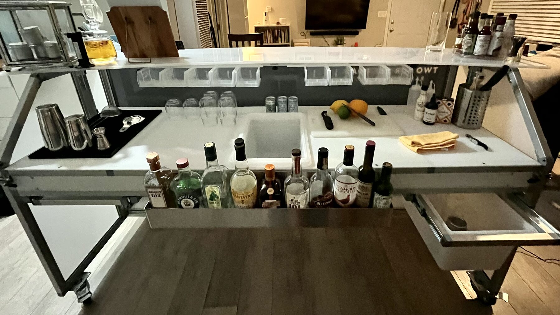 Mobile bar with sink, rinser, bottles, and tools.